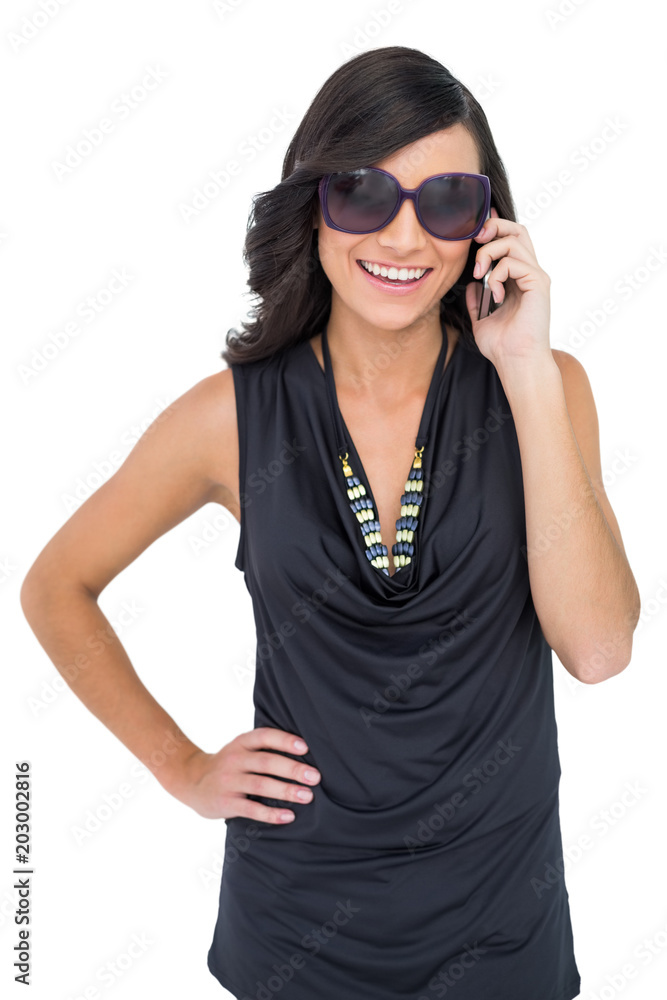 Obraz premium Cheerful elegant brunette on the phone wearing sunglasses