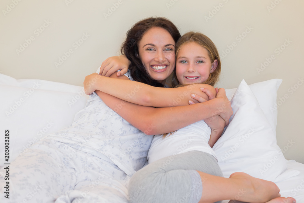 Mother and daughter embracing in bed Mother and daughter embracing in bed