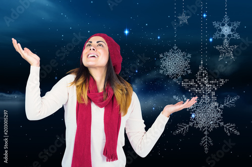 surprised brunette with hands out against snowflakes hanging against starry sky
