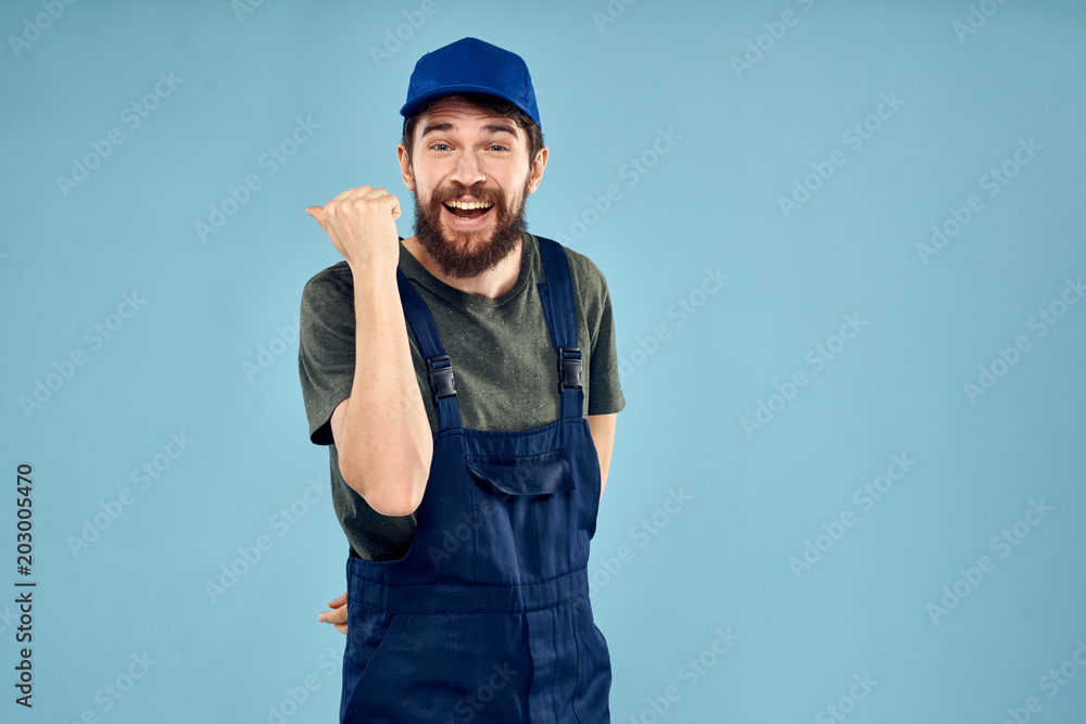 man in blue cap and in jumpsuit is looking at the camera man in blue cap and in jumpsuit is looking at the camera