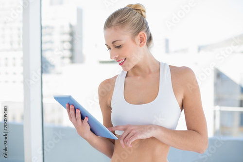 Joyful young blonde model using a tablet pc Free Download Joyful young blonde model using a tablet pc - GFXLoad