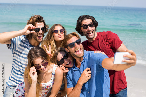 Young friends taking selfie at beach