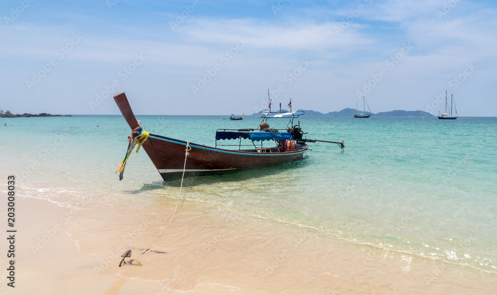 traditional thai boat on the beach for travellers holiday
