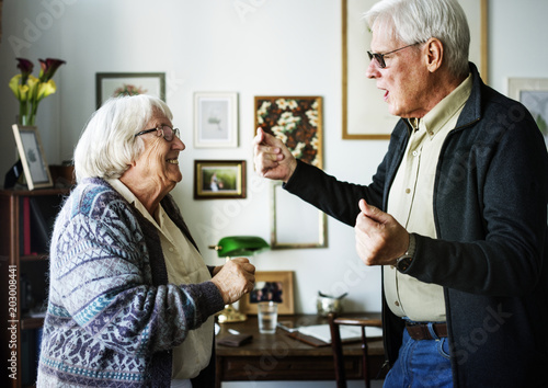 Senior couple dancing together at home