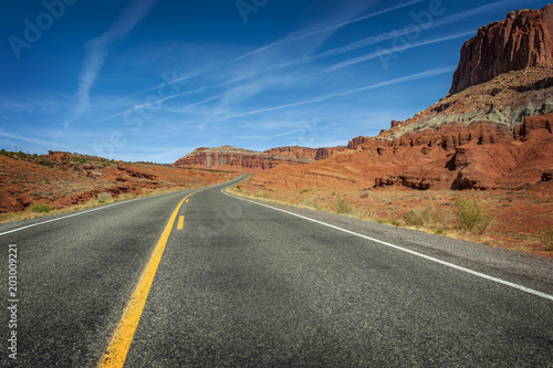 Highway to Capitol Reef National Park, Utah. This highway travels through red sandstone rock canyons and scenic desert terrain.