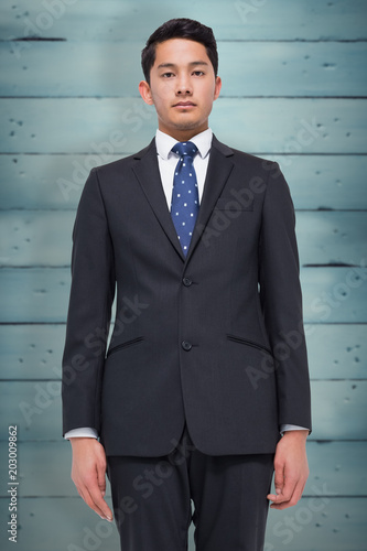 Stern businessman looking at camera against wooden planks © vectorfusionart