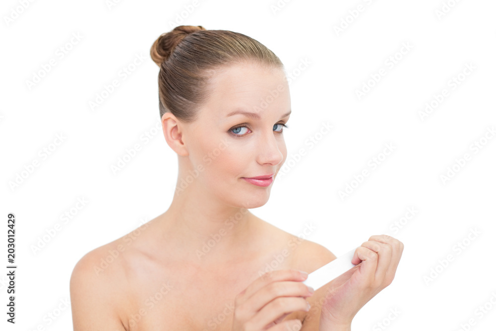 Smiling pretty blonde model filing her nails Smiling pretty blonde model filing her nails