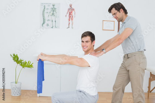 Male therapist assisting young man with exercises © WavebreakmediaMicro