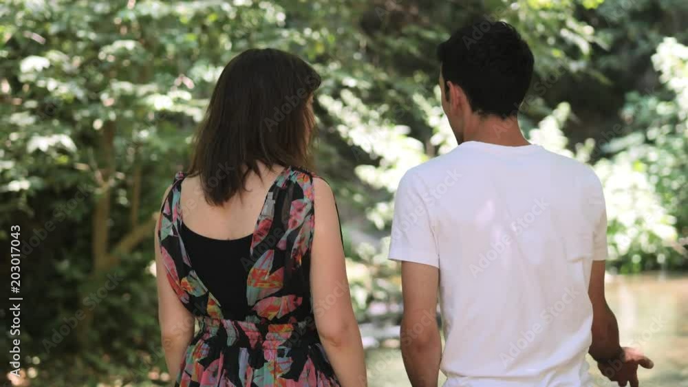 young couple chat happily observing the river young couple chat happily observing the river