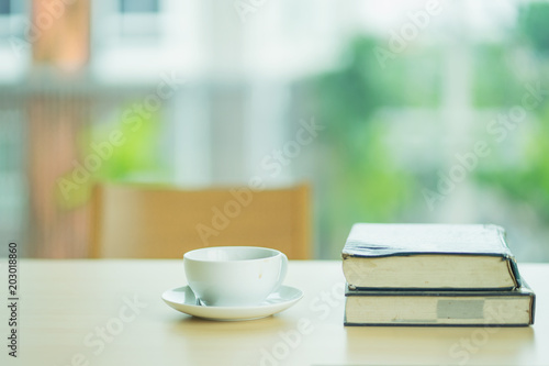 A cup of coffee and book on the wooden table