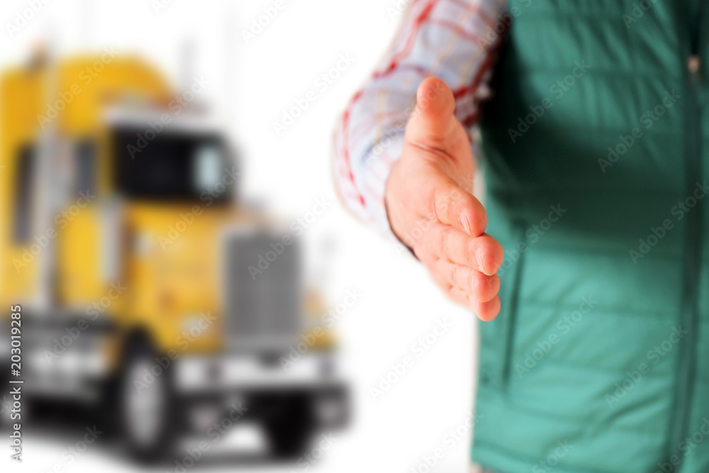 Driver with an open hand greeting . Truck behind him Driver with an open hand greeting . Truck behind him