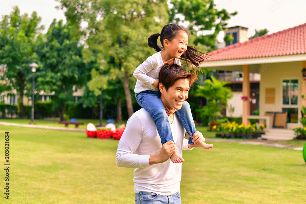 Obraz premium Parents and daughters go for a walk in the park.