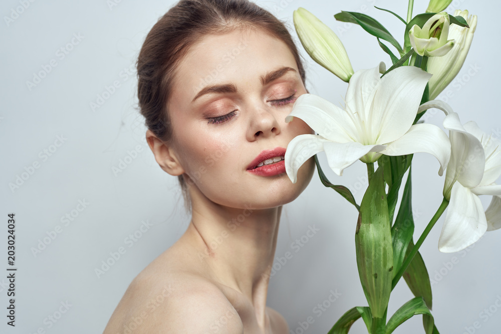 woman with flowers on a light background beauty care
