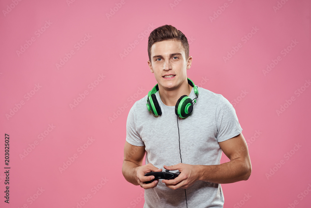 man with headphones with joystick on pink background man with headphones with joystick on pink background
