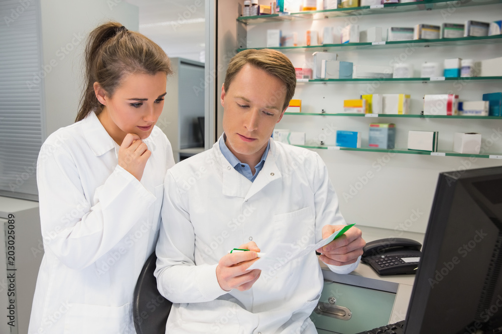 Team of pharmacists looking at prescription