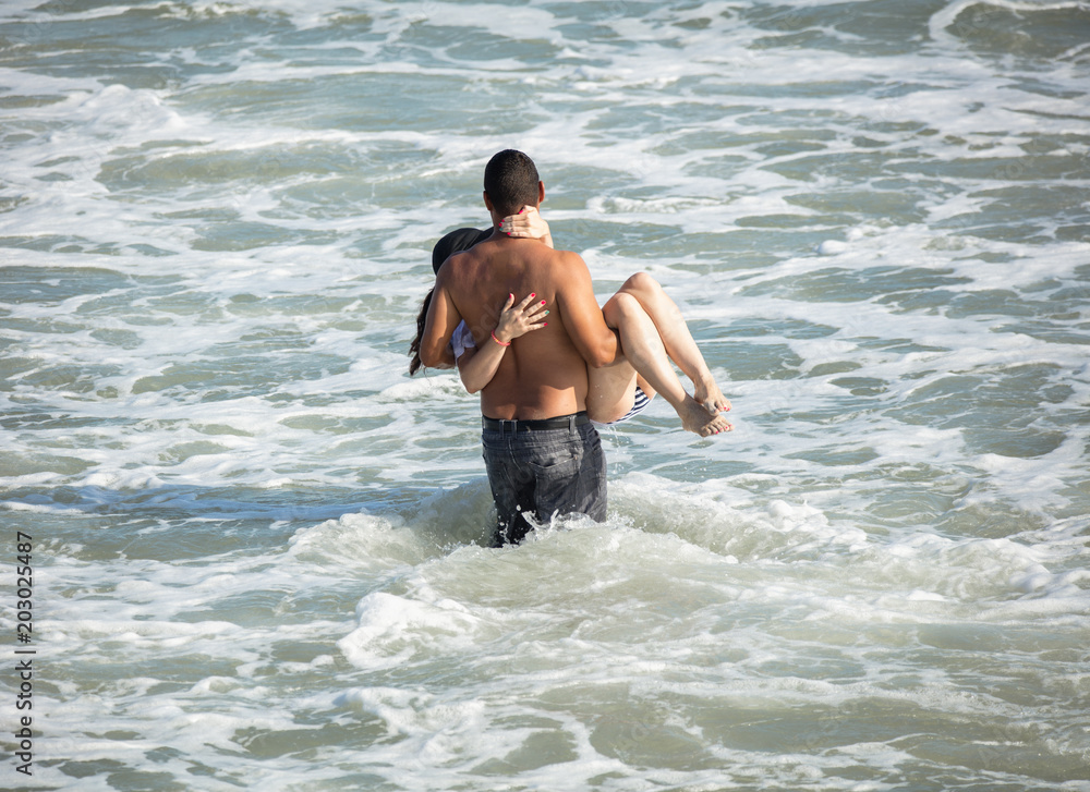 Fototapeta premium unknown romantic couple prepares to take the plunge at their beach side wedding