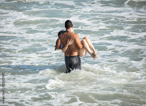 unknown romantic couple prepares to take the plunge at their beach side wedding