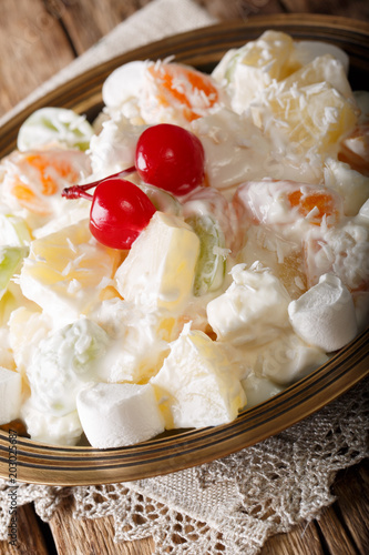 fruit salad Ambrosia from pineapple, tangerine, grapes and marshmelow close-up. vertical