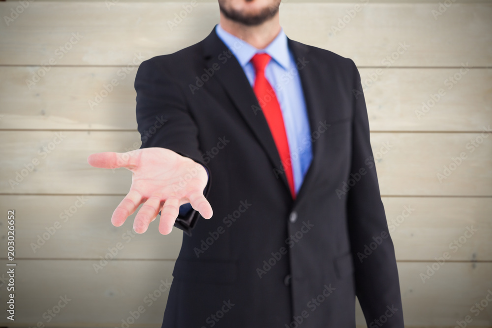 Businessman holding hand out in presentation against bleached wooden planks background Businessman holding hand out in presentation against bleached wooden planks background