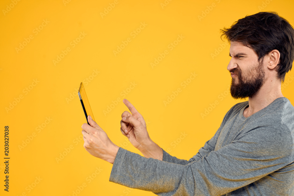 man holding a tablet on a yellow background