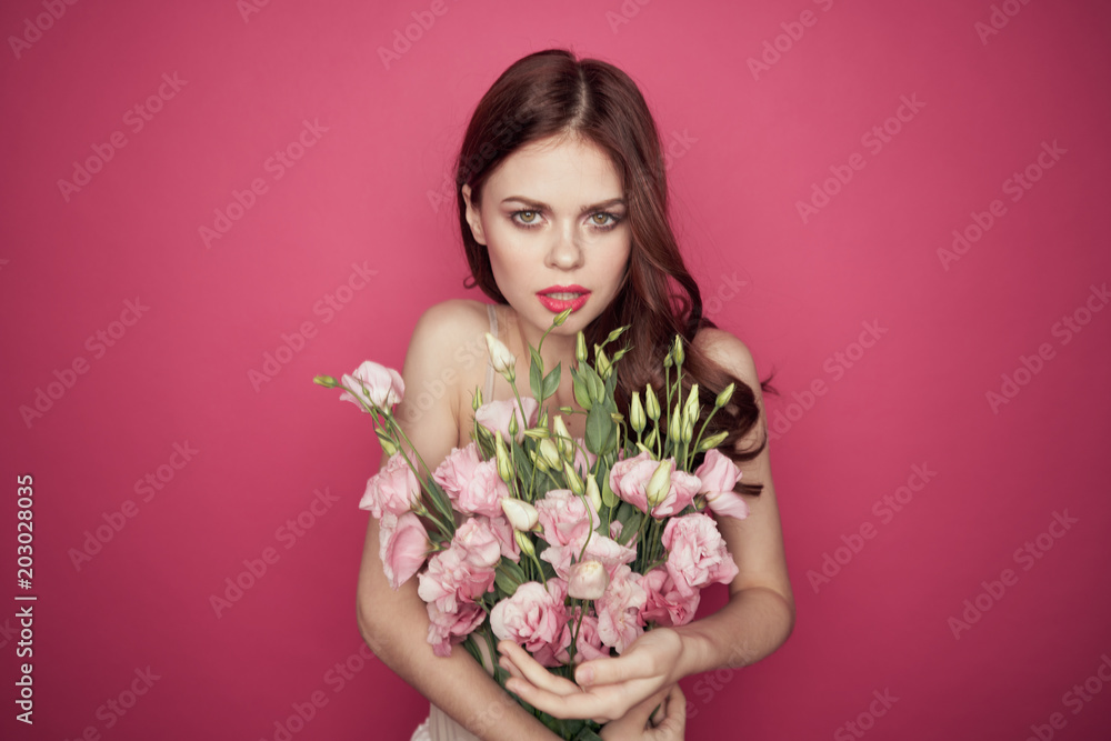 woman with flowers on a pink background