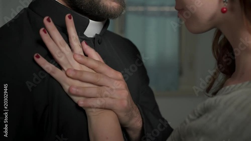 sinners, religion: young priest gives in to the advances of a sexy woman photo