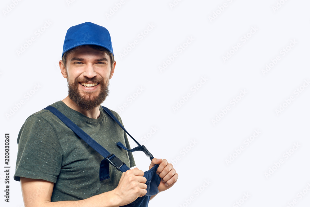 man in blue cap and in overalls on white background
