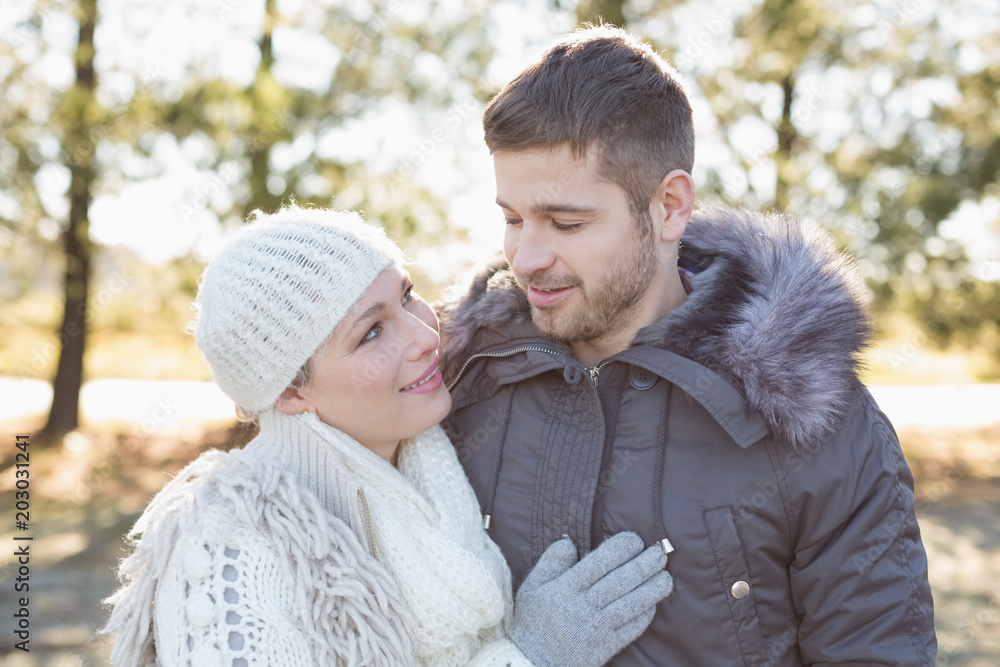 Fototapeta premium Smiling couple in winter clothing in the woods