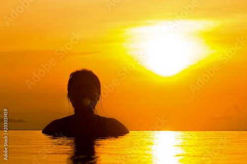Sunset for freedom concept with woman in the water and beautiful silhouette. Totally free and living a healthy life.