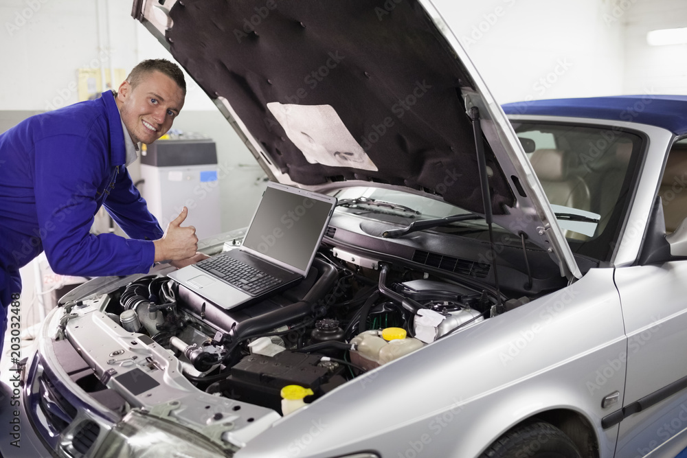 Mechanic leaning on a car engine