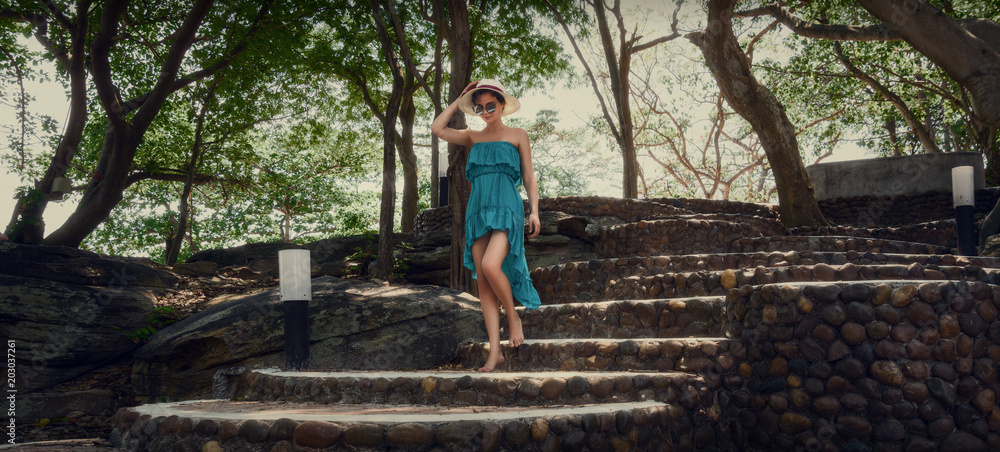 A girl in a turquoise dress is walking along the steps. Walk in the park. A girl in a turquoise dress is walking along the steps. Walk in the park.