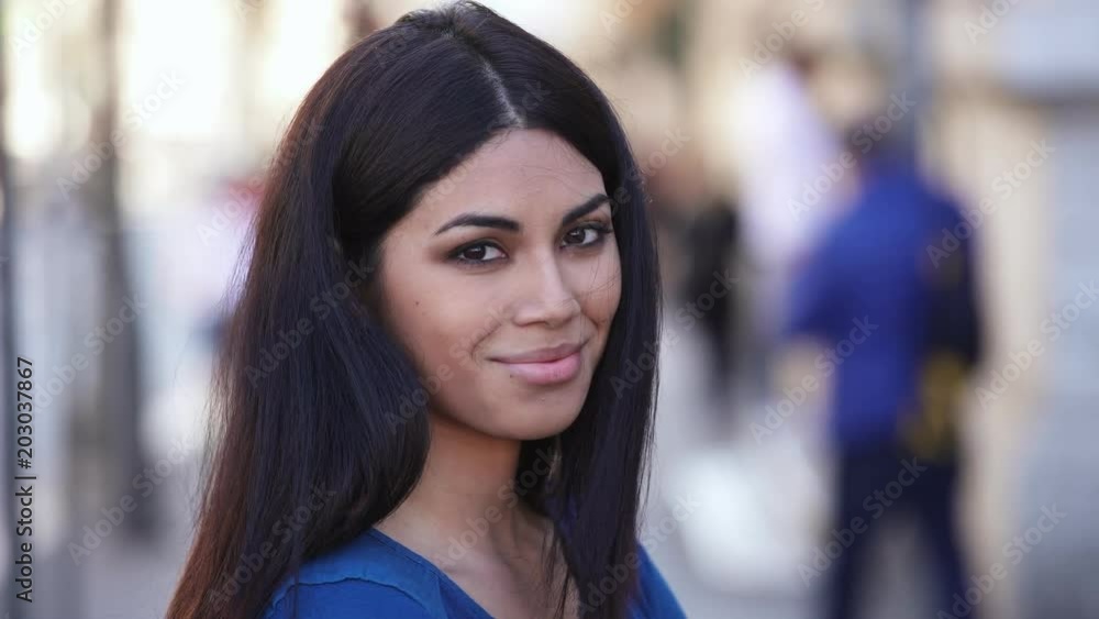 Beautiful young asian woman in the street turning her head and smiling at camera Beautiful young asian woman in the street turning her head and smiling at camera