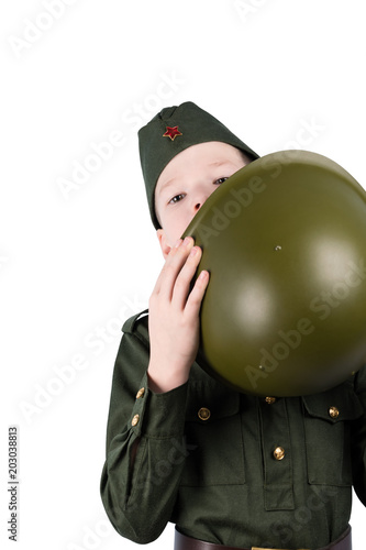 boy in uniform, peeking out from behind a green helmet, isolated on white