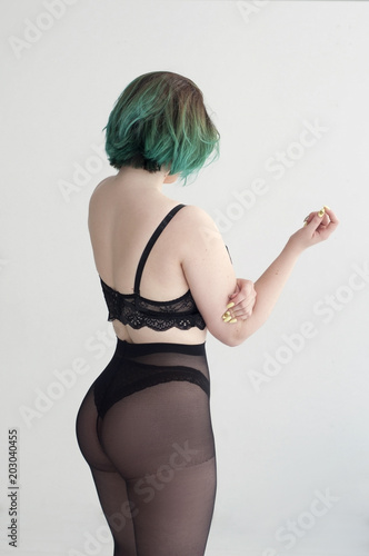 girl in pantyhose and lingerie posing standing with her back