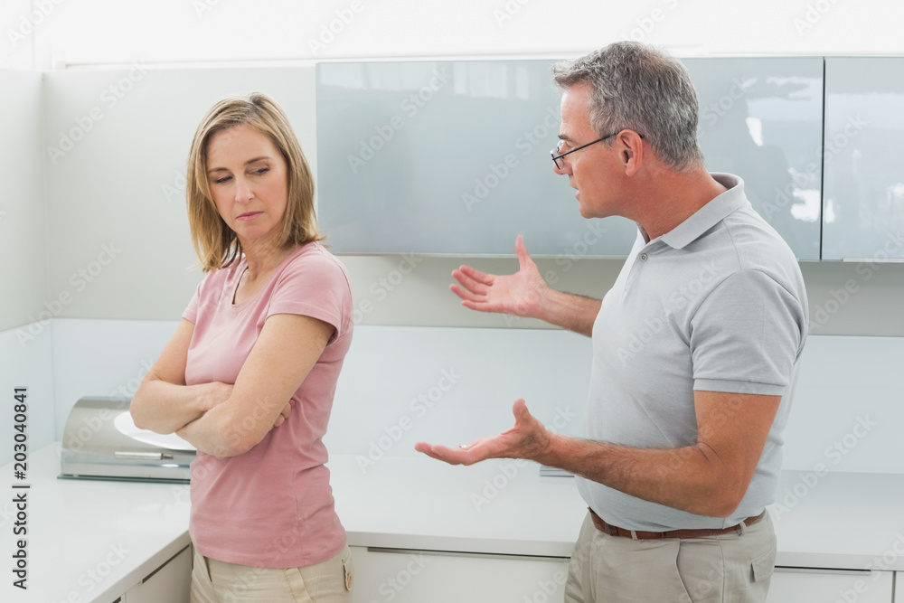 Unhappy couple having an argument in kitchen