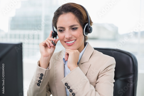 Cheerful businesswoman touching headset