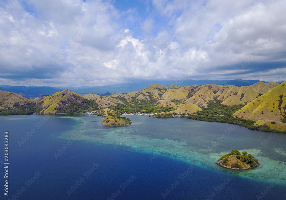 Beautiful aerial view of beaches and tourist boat sailing in Flores Island, Indonesia.