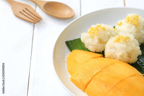Mango and sticky rice in white dish on white wooden floor and have copy space.