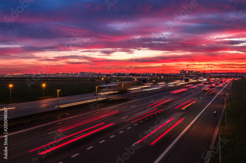 Obraz na płótnie Dramatic sky at dawn with cars lights trails near the international airport of Brussels, Belgium w salonie