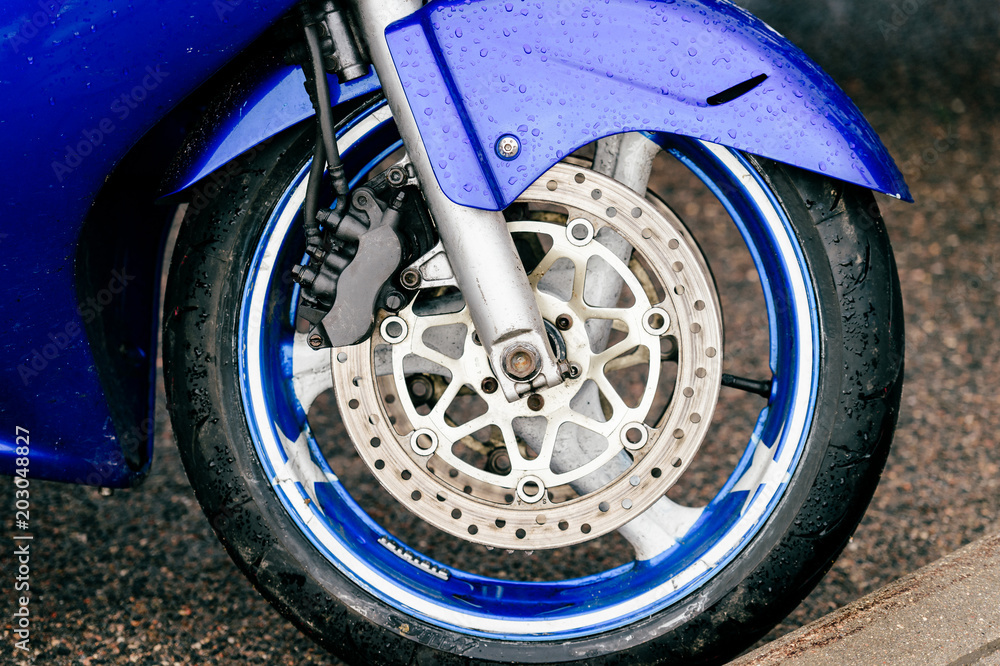 Obraz premium Motorcycle wheel with disk brakes system and metal spokes. Closeup detailed photo of motorbike forks and tire. Different parts of two-wheeled vehicle. Transportation. Modern driving technologies.
