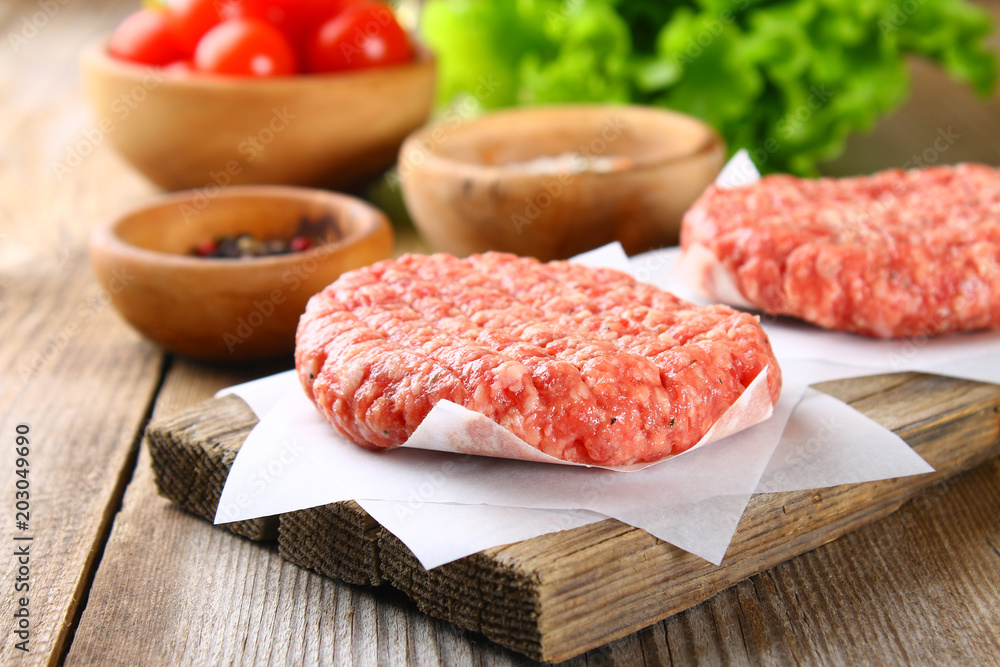 Raw minced meat for home made grill burgers cooking with spaces and herbs.