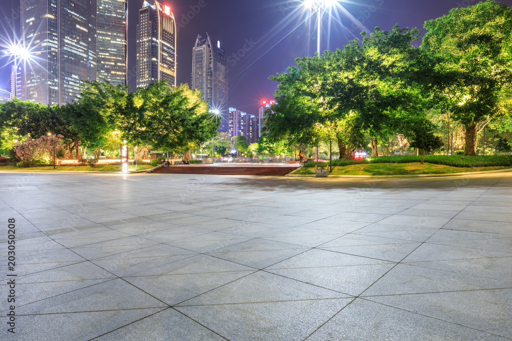 empty square floor and modern city landscape at night