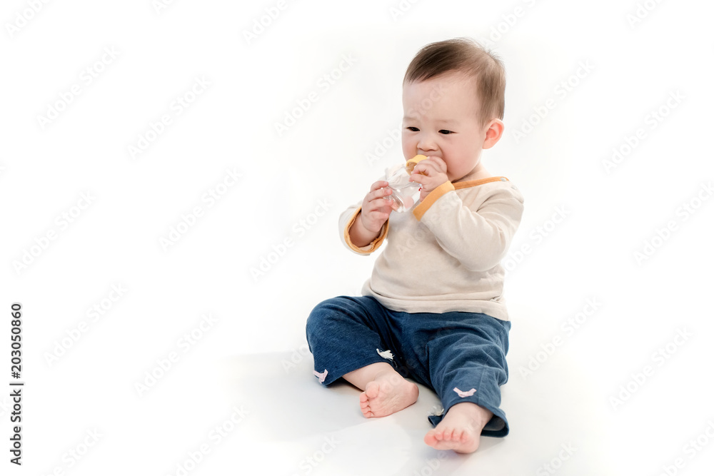 The lovely baby sat on the floor and drank water,White background The lovely baby sat on the floor and drank water,White background
