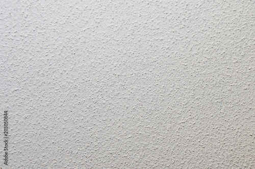 Texture of plastered single-colored gray wall with small dots