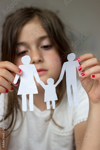 Little girl holds paper chain family; broken family or divorce concept