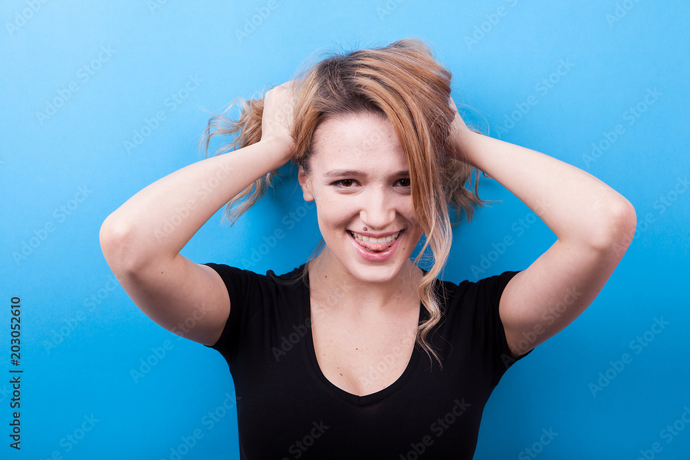 Gorgoeus happy young woman smiling to the camera on blue background in studio photo Gorgoeus happy young woman smiling to the camera on blue background in studio photo