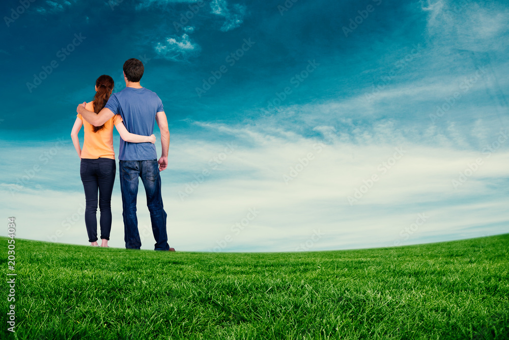 Couple with backs to camera against blue sky Couple with backs to camera against blue sky