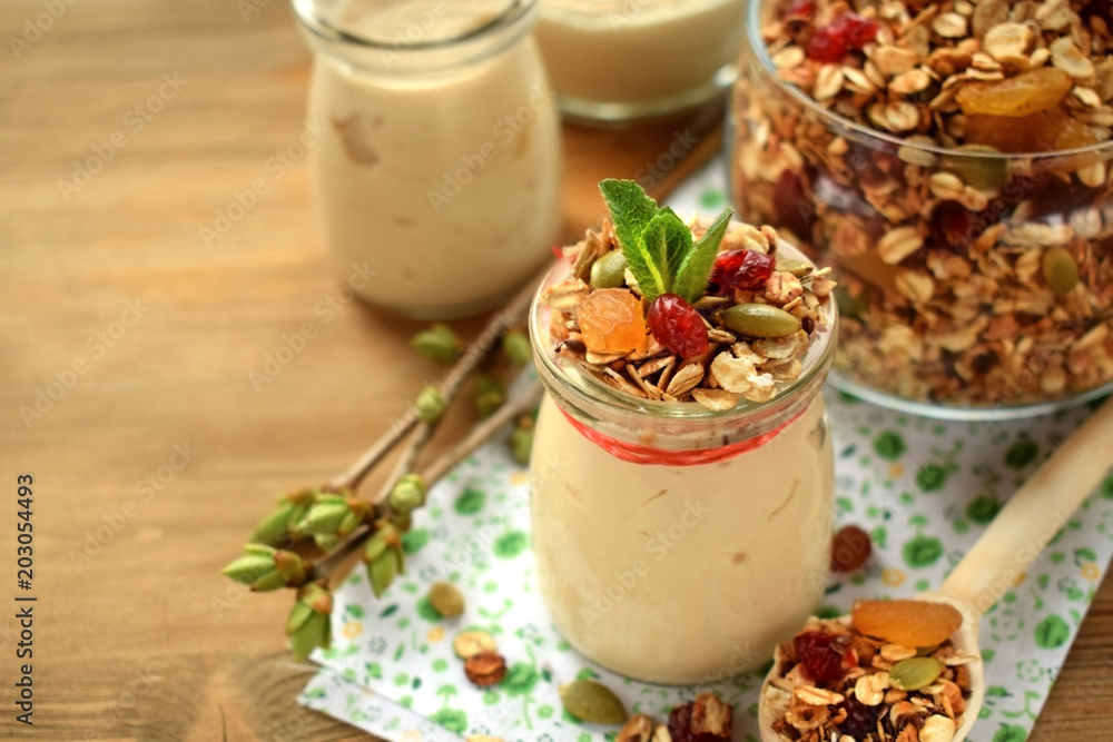 Yogurt in a glass jar topped with granola and mint. Breakfast idea Yogurt in a glass jar topped with granola and mint. Breakfast idea