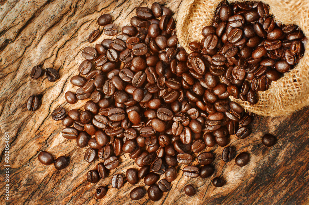 Obraz premium Coffee beans on grunge wooden background.
