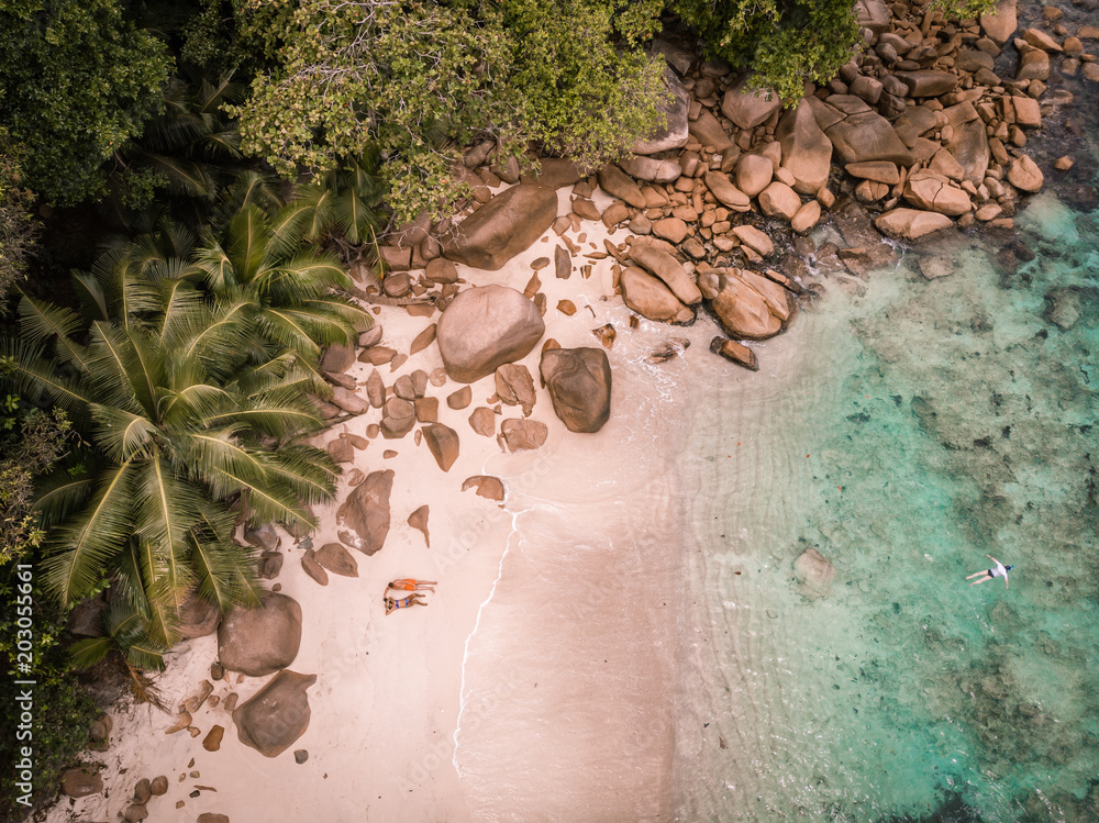 Φωτογραφία Happy couple sun bathing on the beach, drone view of couple on the beach Seychel